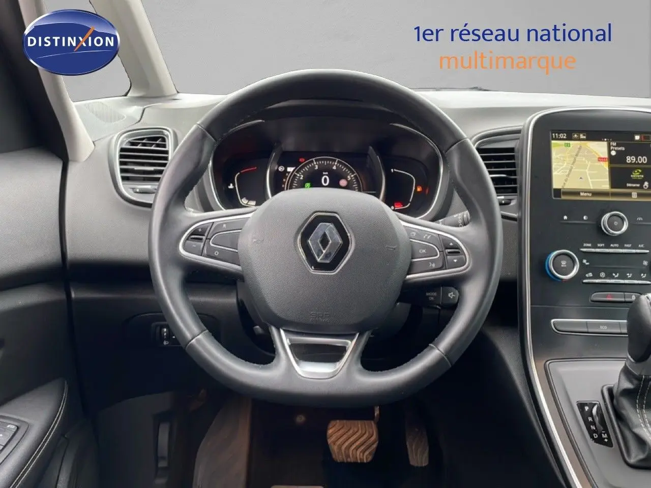 Vue intérieure centrée sur le volant noir du Renault Grand Scenic 2022 avec tableau de bord et écran tactile.