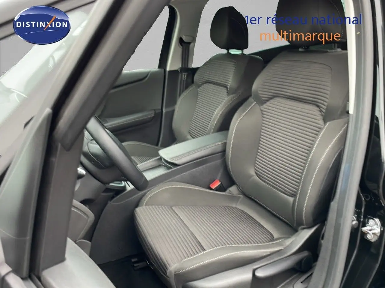 Vue intérieure côté conducteur du Renault Grand Scenic noir étoile métal, mettant en valeur les sièges avant en tissu et cuir.