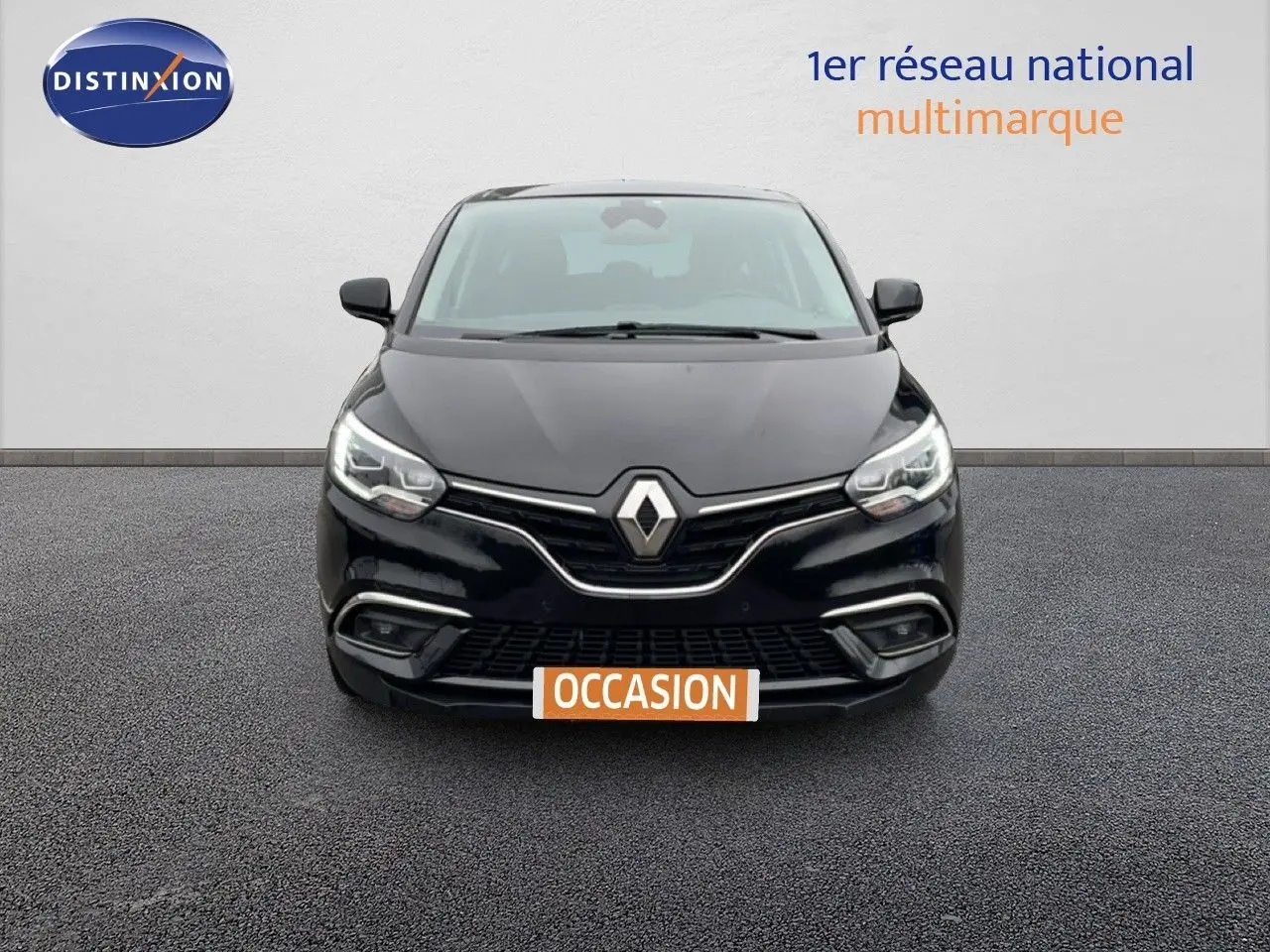 Vue frontale d'un Renault Grand Scenic noir étoile métal avec logo et calandre chromée visibles.