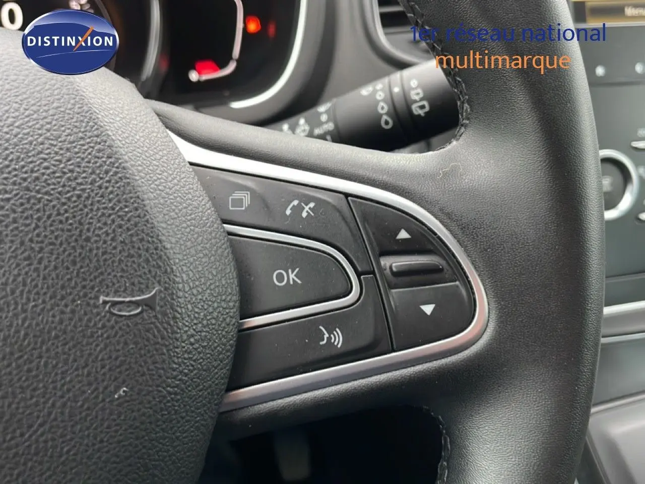 Gros plan sur le volant noir multifonction du Renault Grand Scenic 2022, avec commandes intégrées et finition cuir.