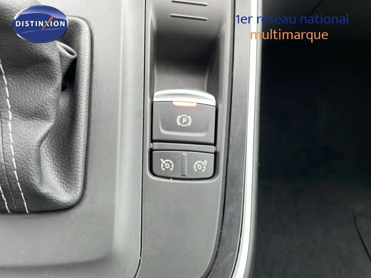 Gros plan sur la console centrale du Renault Grand Scenic noir étoile métal, montrant le frein à main électrique et commandes de régulateur.