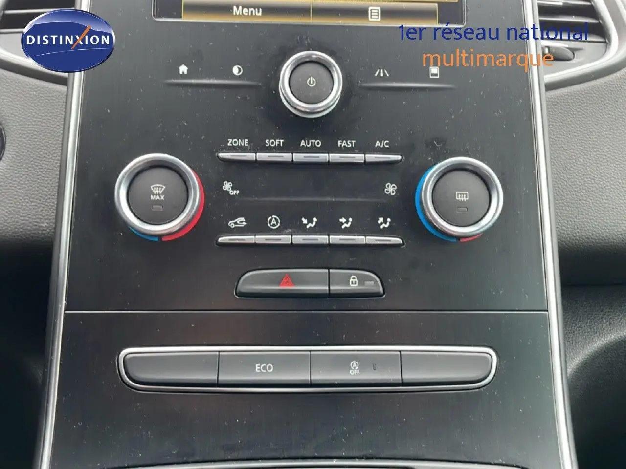 Vue rapprochée de la console centrale noire du Renault Grand Scenic 2022 avec commandes de climatisation et écran tactile.