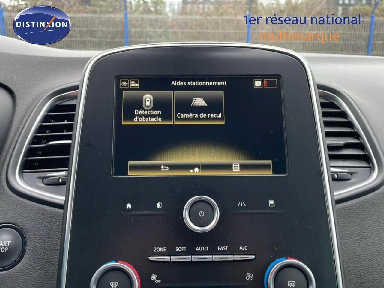 Écran central tactile du Renault Grand Scenic 2022 affichant les aides au stationnement, intérieur noir.