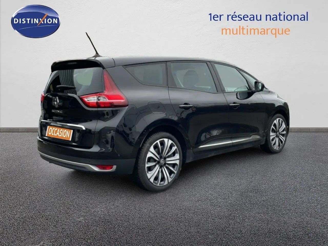 Vue 3/4 arrière droite d'un Renault Grand Scénic noir étoile métal, avec feux arrière distinctifs et jantes alliage.