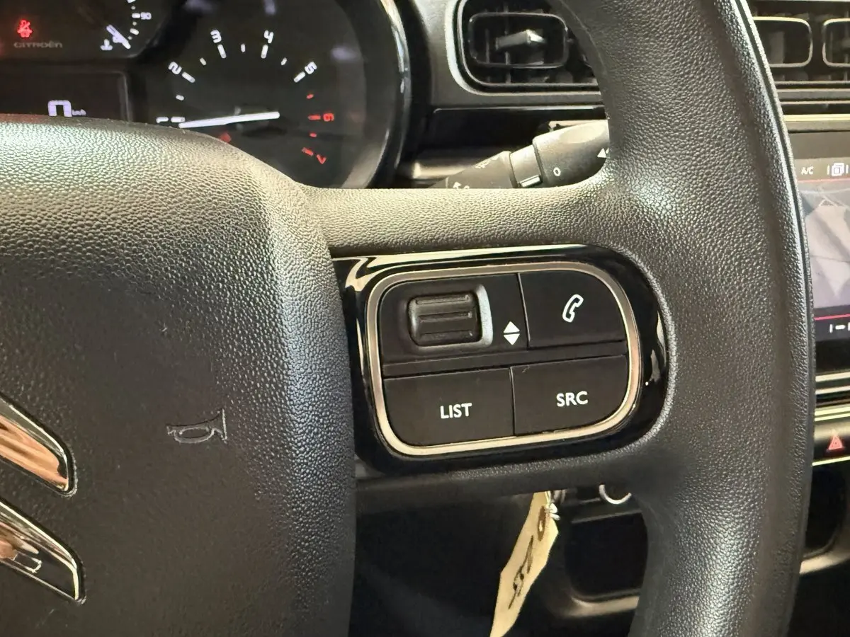 Gros plan sur le volant multifonctions noir de la Citroën C3 2021, avec commandes audio et téléphone visibles.
