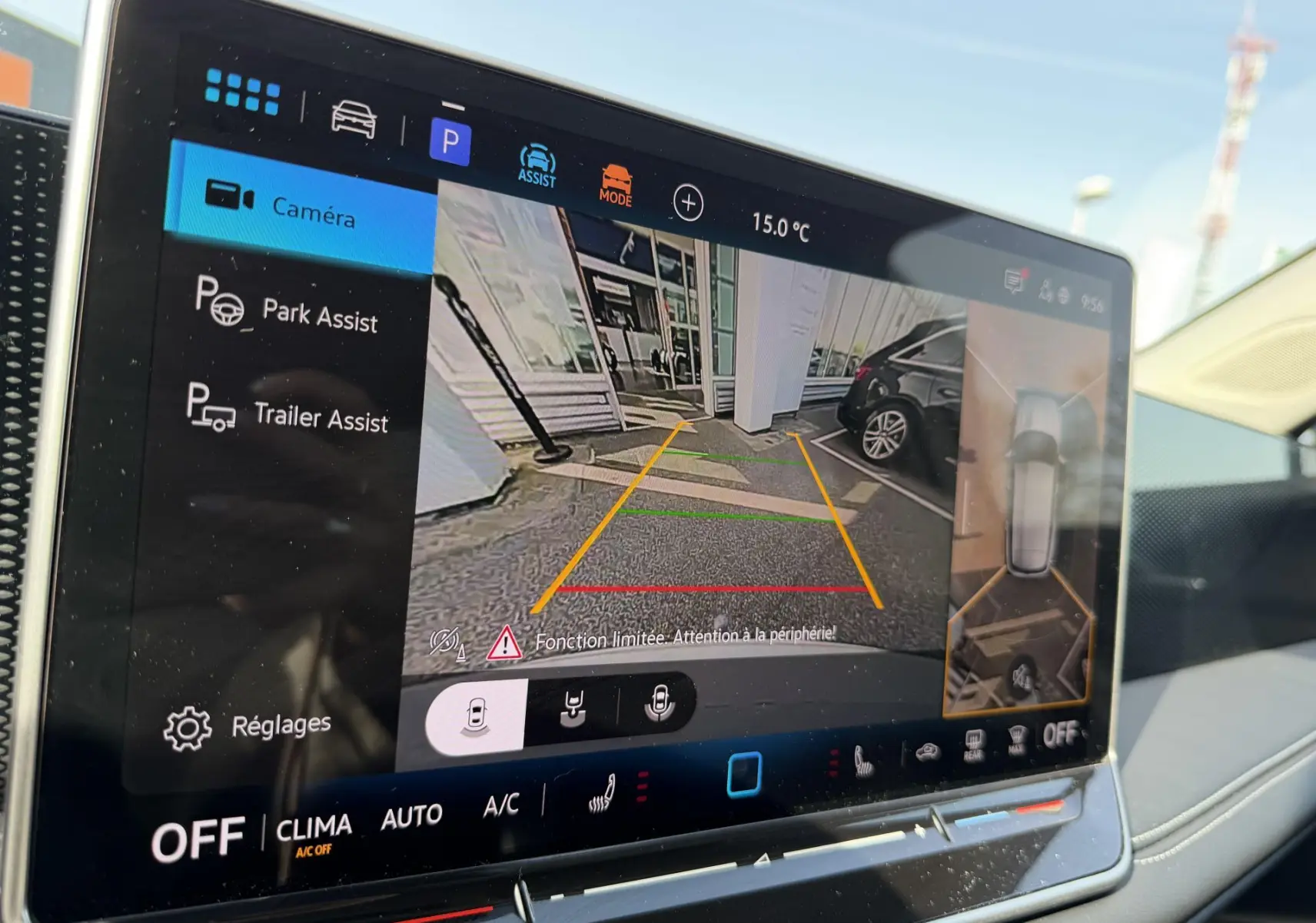 Écran intérieur du Volkswagen Tiguan blanc montrant la caméra de recul et l'assistance au stationnement en vue arrière.