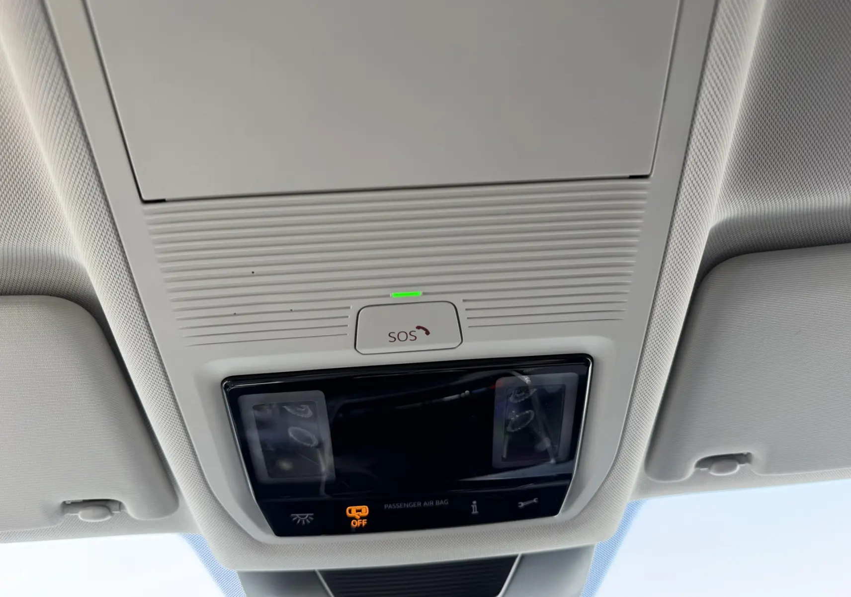 Vue intérieure du plafonnier du Volkswagen Tiguan blanc 2025 avec bouton SOS et éclairage intégré.