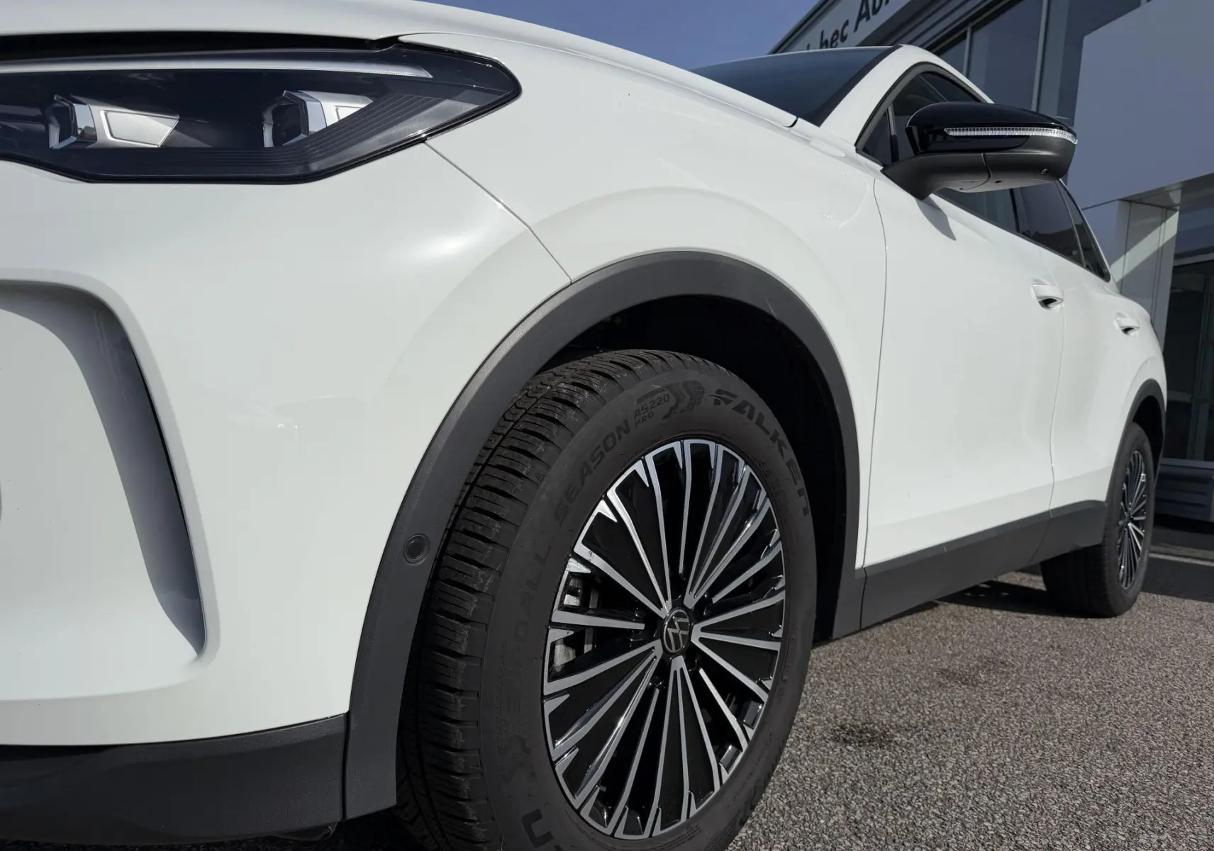 Vue de profil avant droit du Volkswagen Tiguan blanc 2025, mettant en valeur la jante alliage noire brillante Napoli.