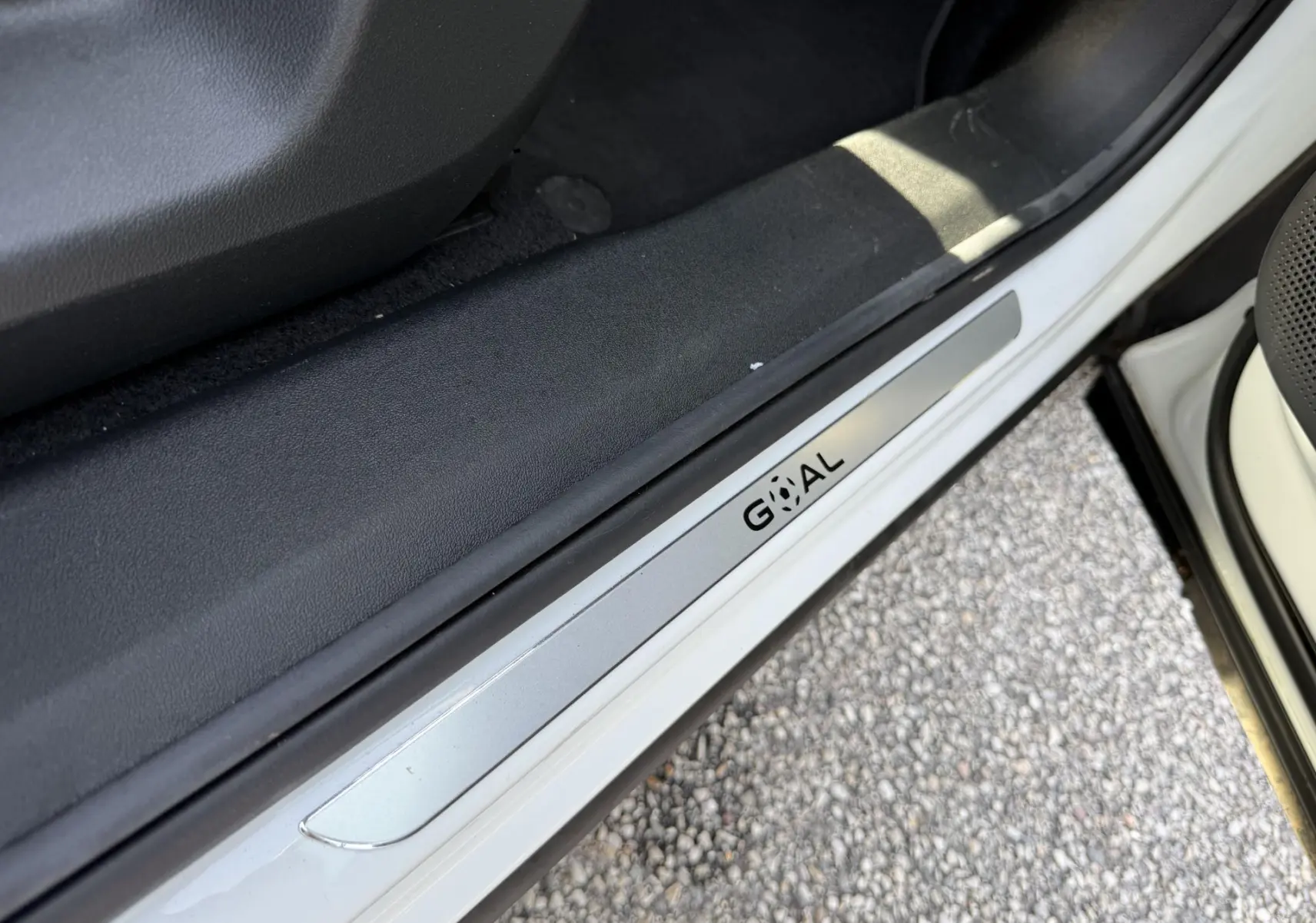 Gros plan sur la plaque de seuil de porte côté gauche du Volkswagen Tiguan blanc, avec inscription "GOAL".