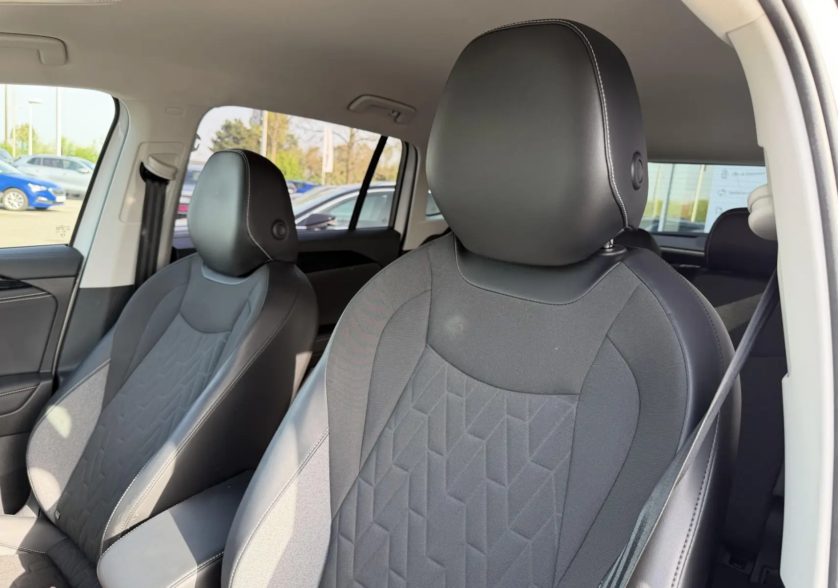 Gros plan sur les sièges avant en tissu et cuir noir du Volkswagen Tiguan 2025, vue côté droit depuis l'intérieur.