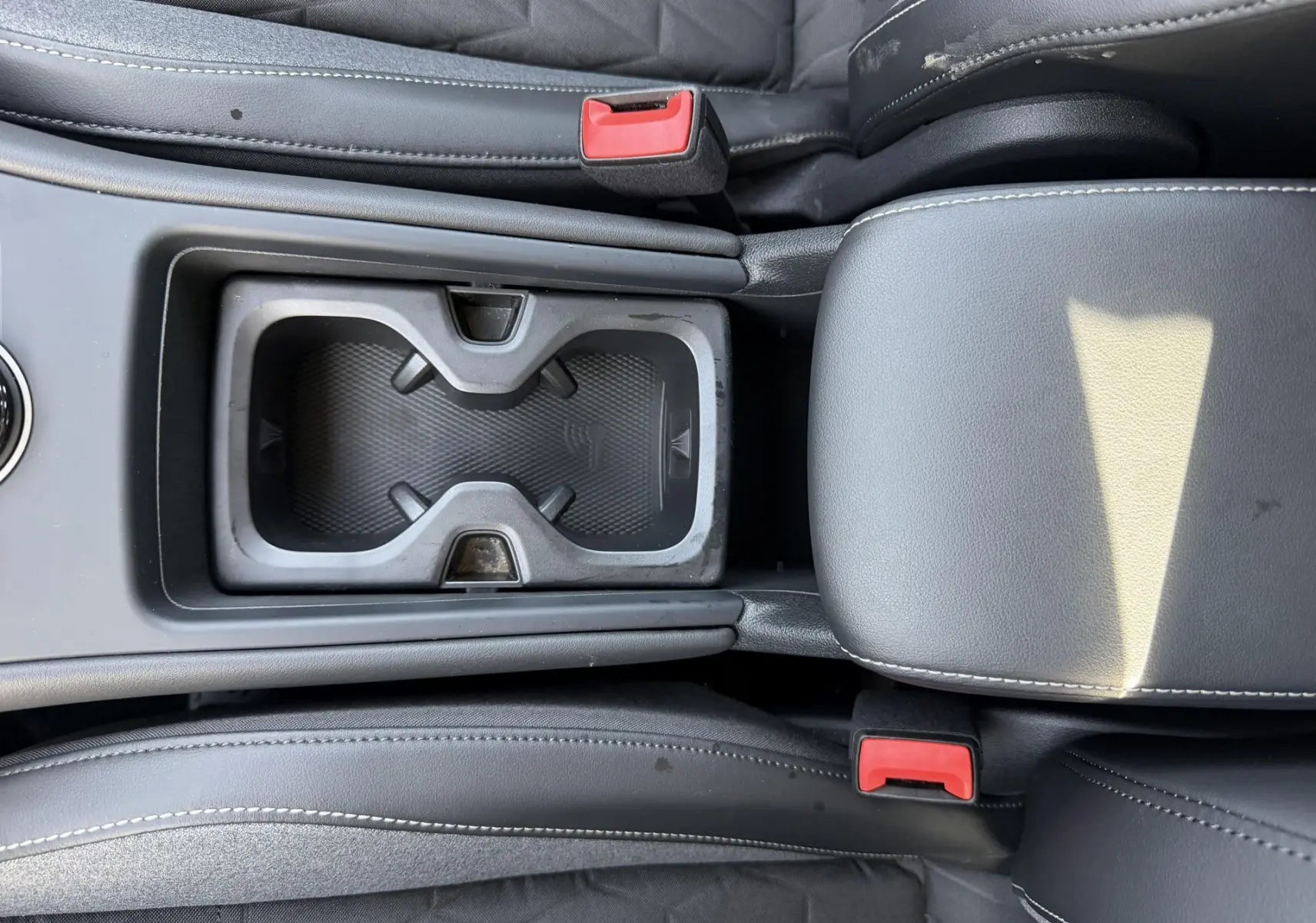 Vue rapprochée de la console centrale noire avec porte-gobelets et accoudoir du Volkswagen Tiguan 2025.