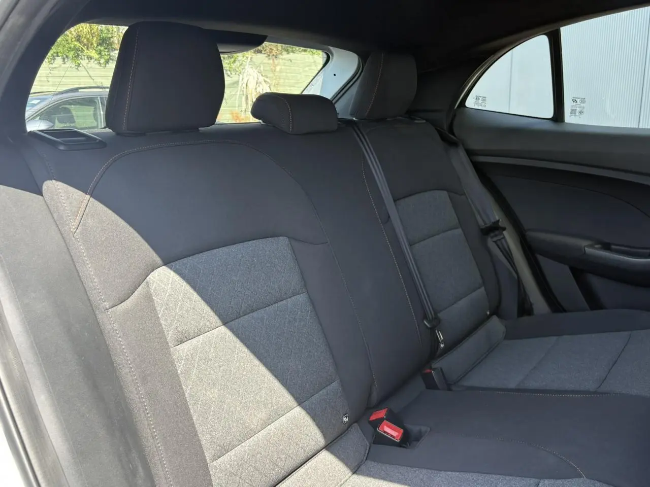 Vue intérieure des sièges arrière en tissu noir du MG3 1.5 Hybrid+ 195 Comfort, avec appuie-têtes et ceintures visibles.