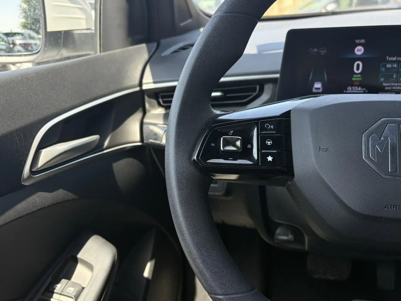 Vue intérieure côté gauche du volant noir de la MG3 1.5 Hybrid+ 195 Comfort avec tableau de bord numérique.