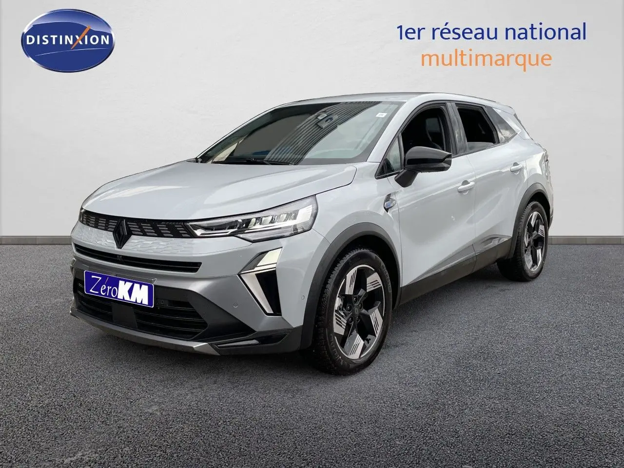 Renault Symbioz gris Rafale métal en 3/4 avant droit, SUV hybride avec calandre noire et jantes bicolores distinctives.