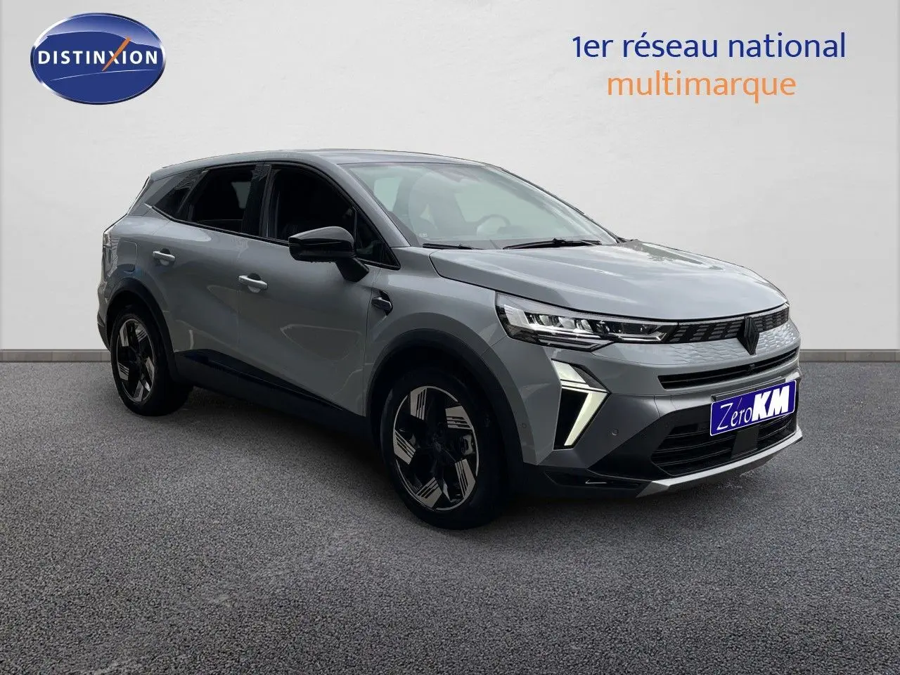 Renault Symbioz gris Rafale métal en 3/4 avant droit, SUV hybride avec feux LED et jantes bicolores distinctives.