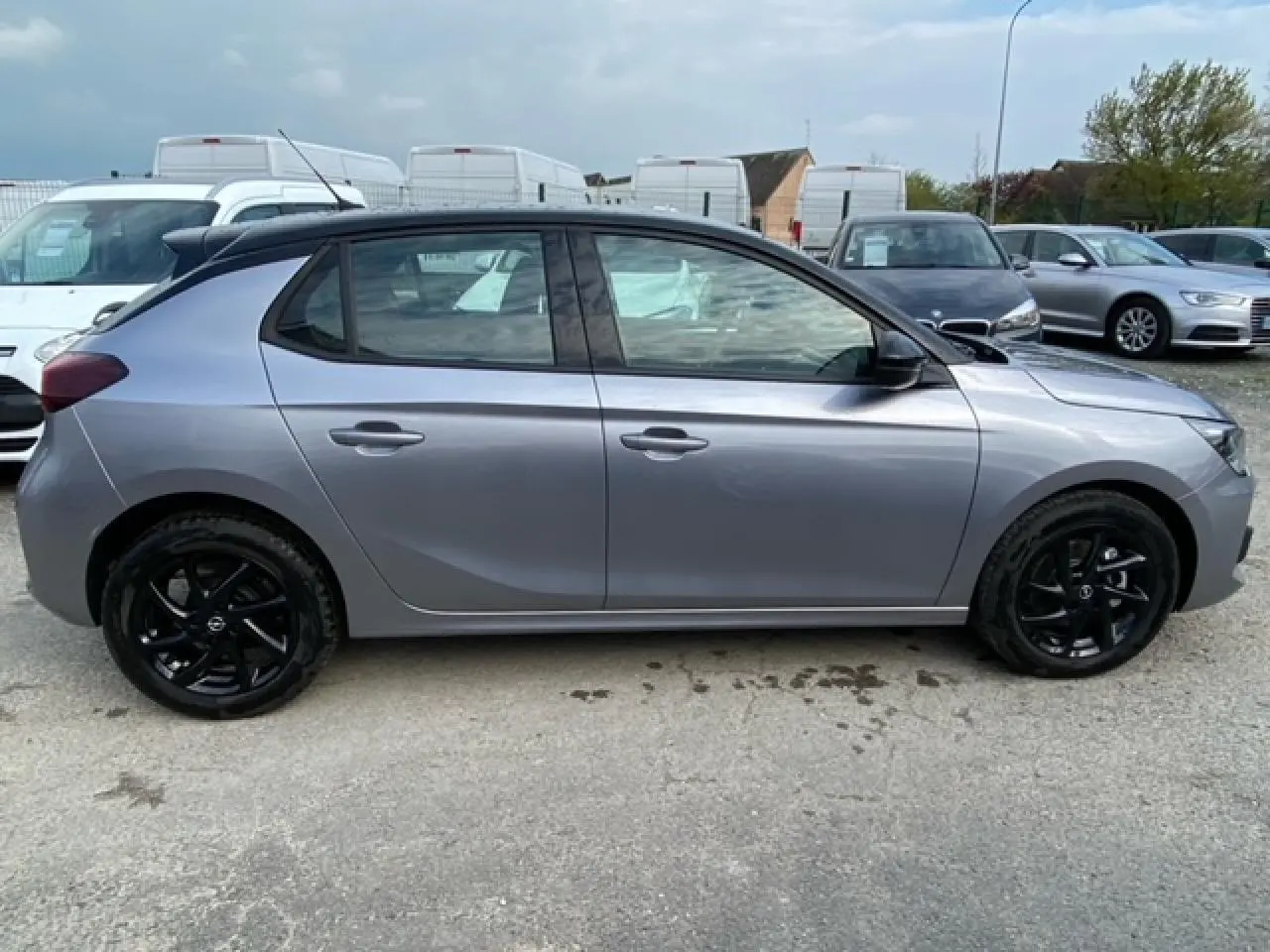 Profil côté gauche d'une Opel Corsa 2022 gris magnetic avec toit noir et jantes alliage noires brillantes.