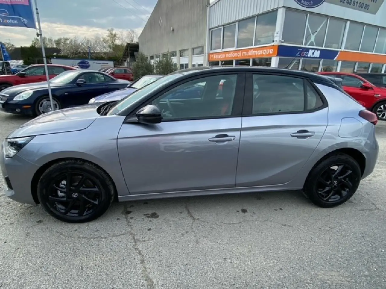 Opel Corsa gris magnetic vue de profil côté gauche avec jantes noires et toit noir contrasté.