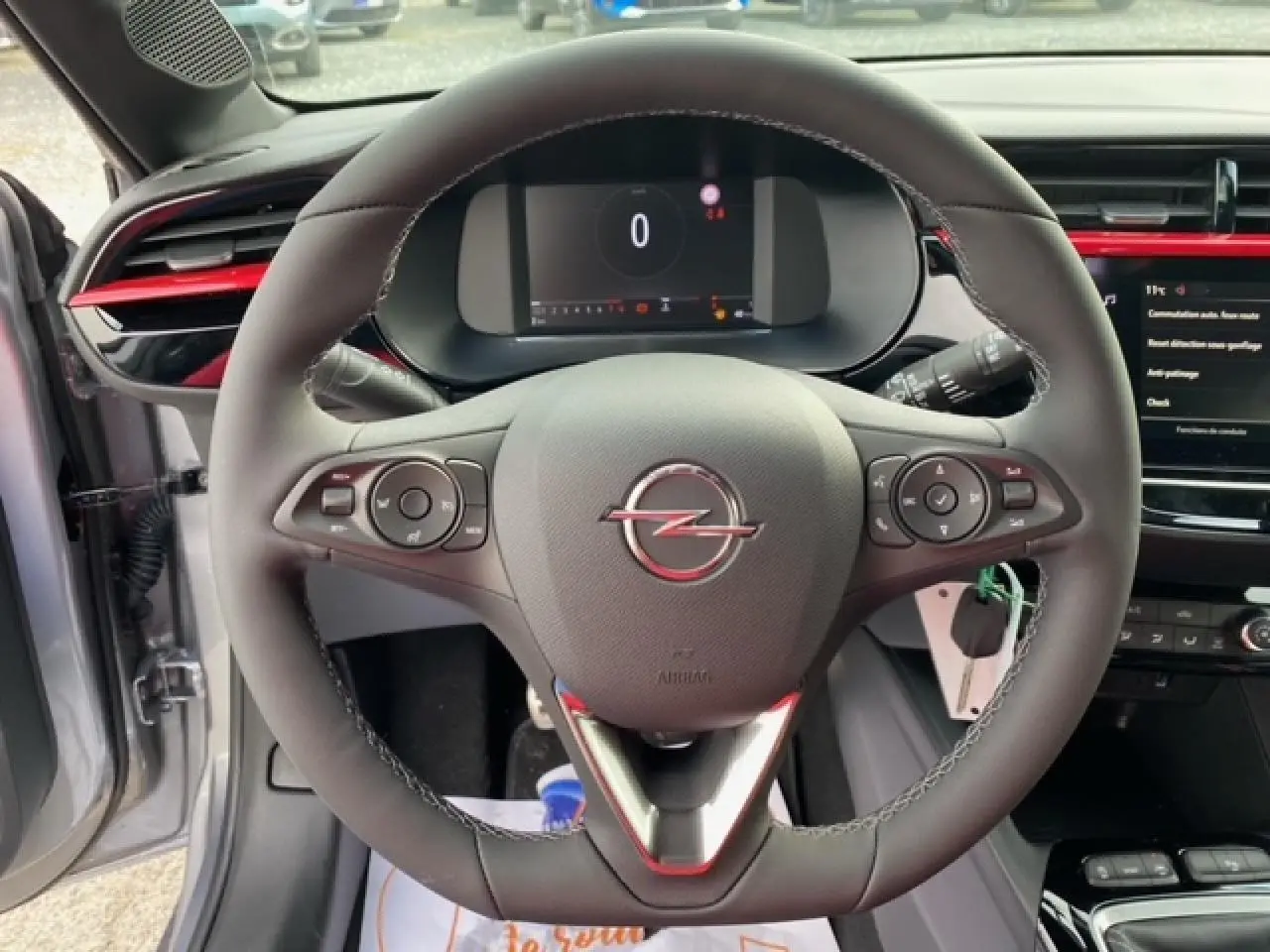 Vue rapprochée du volant noir de l'Opel Corsa 2022 gris magnetic, avec tableau de bord numérique et insert rouge.