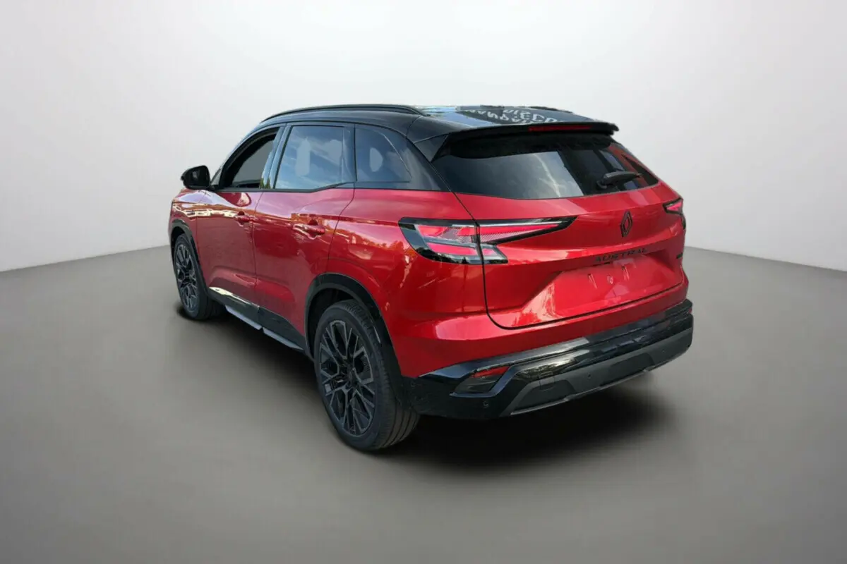 Vue 3/4 arrière droite d'un Renault Austral 2025 rouge avec toit noir et jantes noires distinctives.