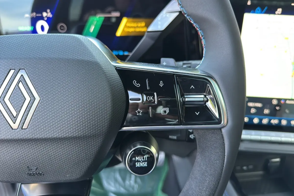 Gros plan sur le volant du Renault Austral New 200 Esprit Alpine 2025, avec commandes multifonctions et bouton Multi Sense.