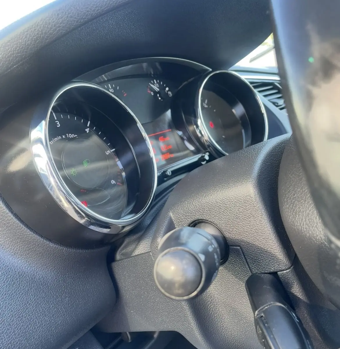 Gros plan sur le tableau de bord du Peugeot 3008 2016, avec compteurs ronds et affichage digital rouge.