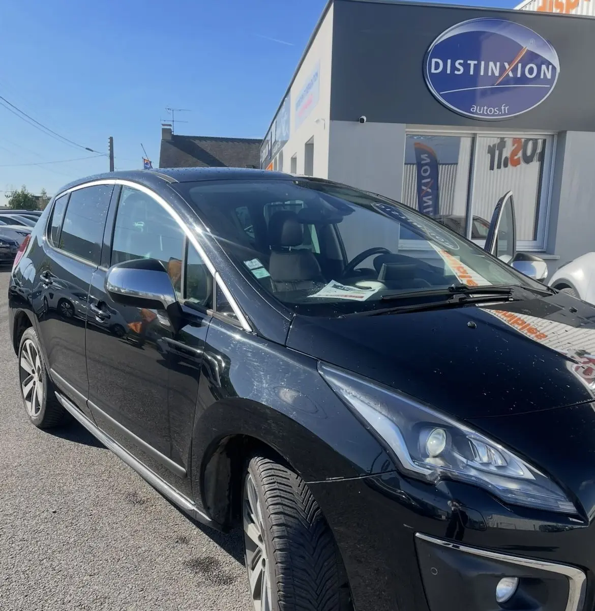 Peugeot 3008 noir vue 3/4 avant droit, avec phares bi-xénon et toit panoramique sous un ciel bleu.