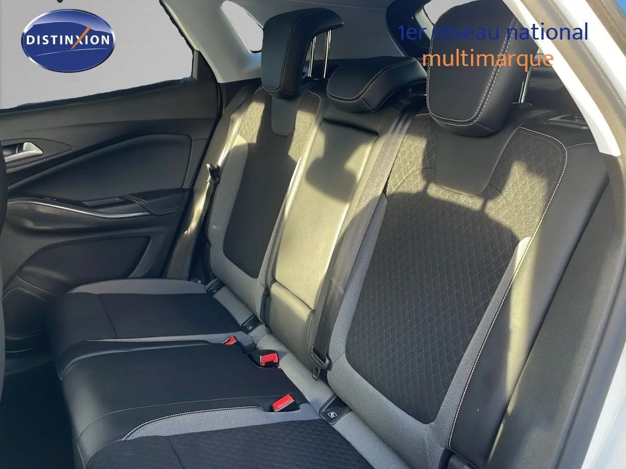 Vue latérale des sièges arrière en cuir noir et tissu gris d'un Opel Grandland X blanc toit noir de 2020.