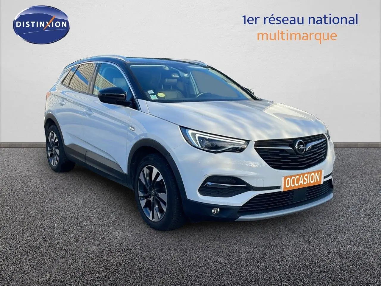 Opel Grandland X blanc toit noir en 3/4 avant droit avec jantes alliage et calandre noire distinctive.