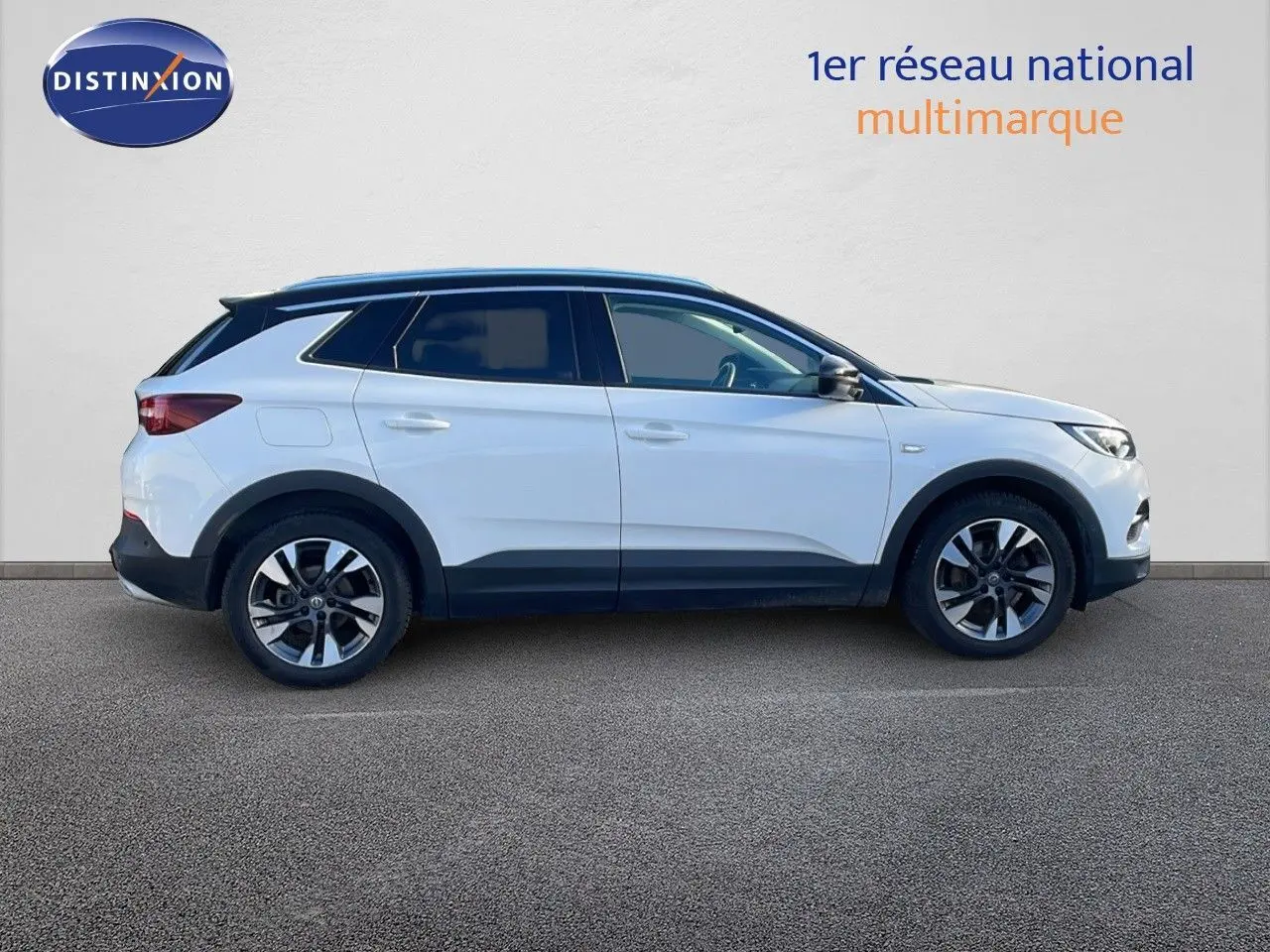 Profil côté gauche d'un Opel Grandland X blanc avec toit noir, roues alliage et lignes modernes visibles.
