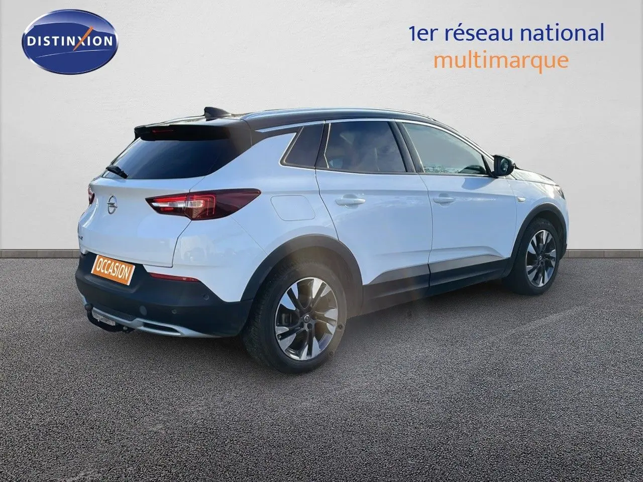 Opel Grandland X blanc toit noir en 3/4 arrière droit, mettant en valeur ses jantes et son hayon fermé.