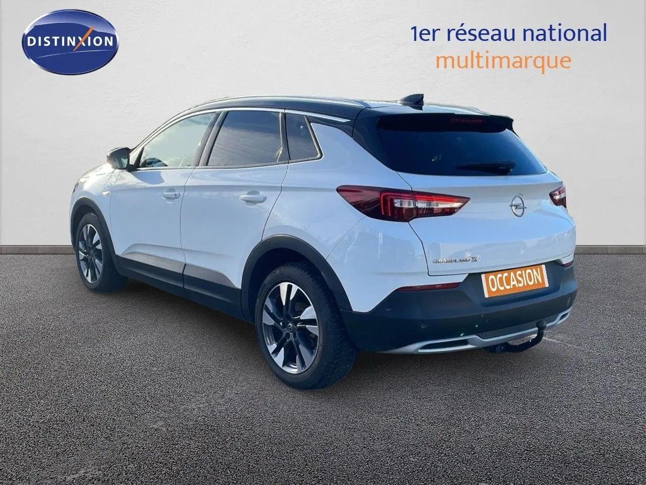 Opel Grandland X blanc toit noir en 3/4 arrière droit, SUV compact avec jantes alliage et hayon fermé.
