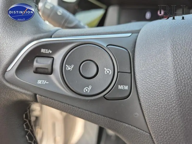 Gros plan sur les commandes du régulateur de vitesse au volant cuir noir de l'Opel Grandland 2023 Design&Tech.