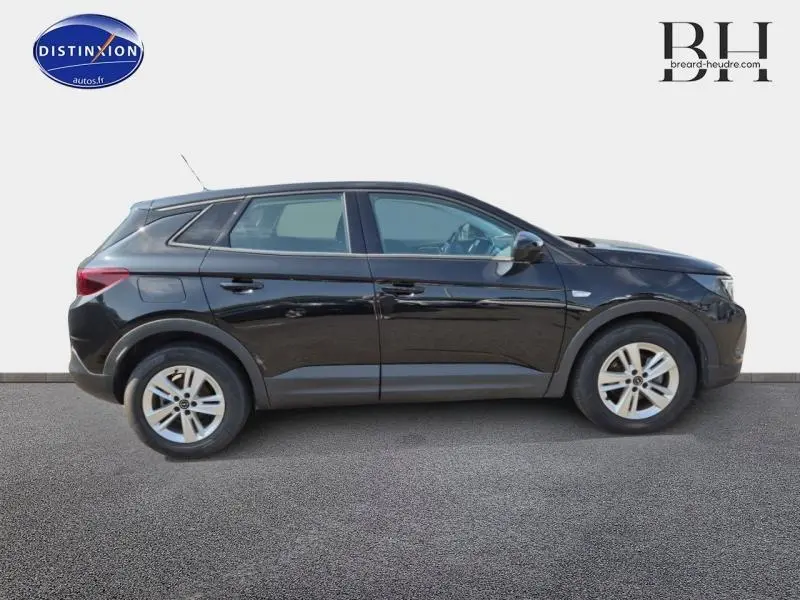 Profil côté gauche d'un Opel Grandland 2023 noir Karbon métallisé avec jantes alu et lignes épurées.