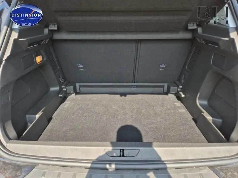 Coffre spacieux ouvert de l'Opel Grandland 1.2 Turbo 130ch Design&Tech noir Karbon, vue arrière intérieure sur tapis et rangements.