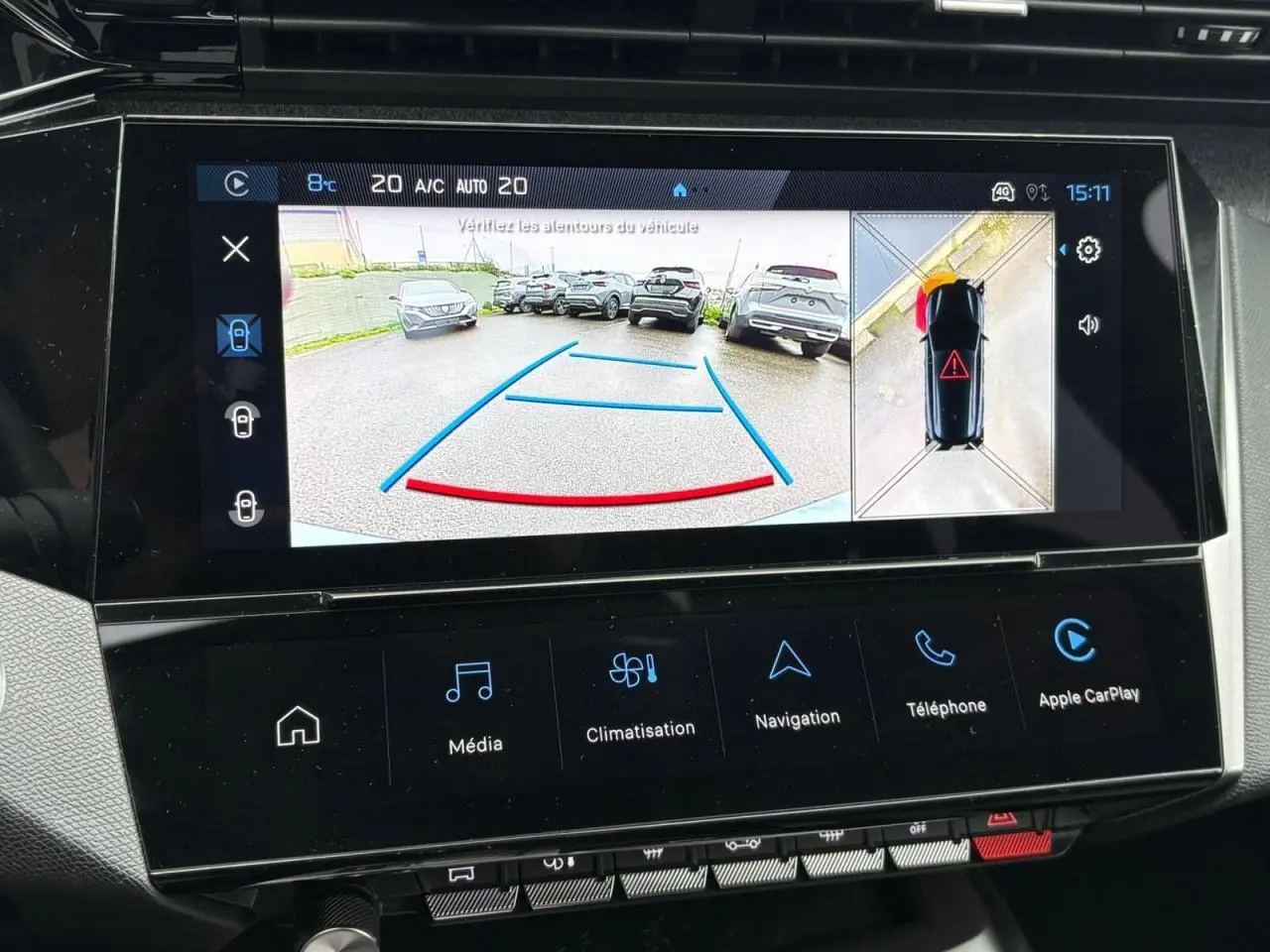 Écran tactile central de la Peugeot 308 SW Hybrid bleu cuivre montrant la caméra 360° en vue arrière et dessus.