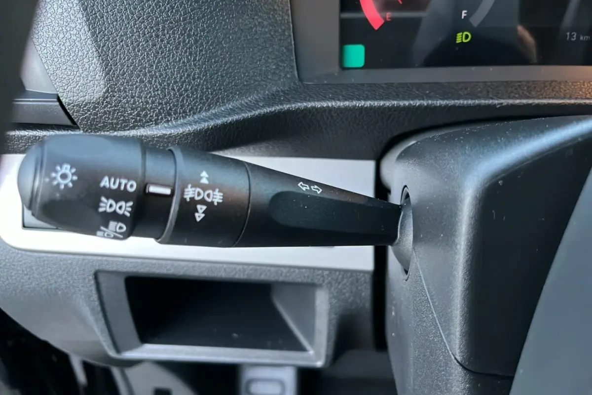 Gros plan sur la commande des feux et clignotants à gauche du volant du Fiat Scudo Fourgon noir 2025.