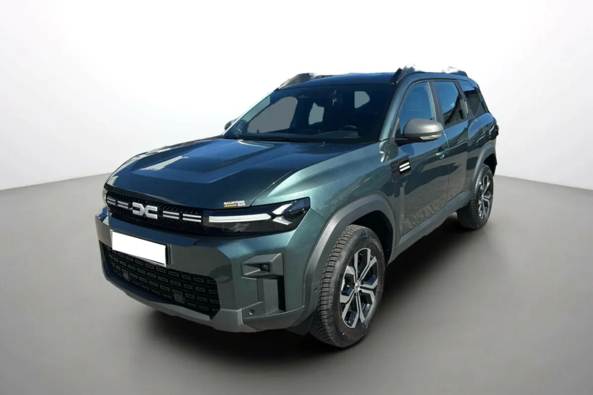 Dacia Bigster TCE 130 4x4 vert cèdre en 3/4 avant droit avec jantes alu 17 pouces et barres de toit noires.