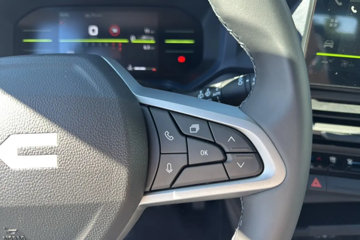 Gros plan sur le volant cuir du Dacia Bigster 2025, mettant en valeur les commandes multifonctions à droite.