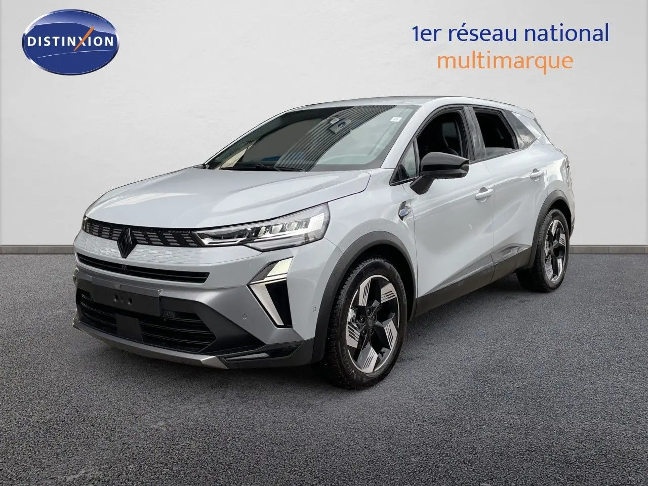 Renault Symbioz gris Rafale métal en 3/4 avant droit, SUV hybride avec phares LED et jantes bicolores distinctives.