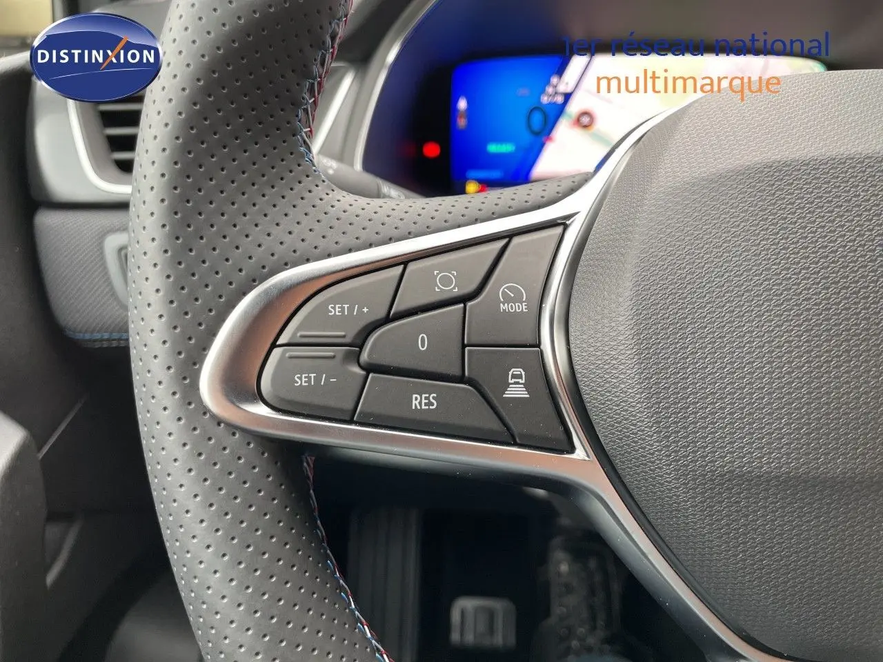 Gros plan sur la partie gauche du volant perforé gris du Renault Symbioz 2026 avec commandes de régulateur et mode.