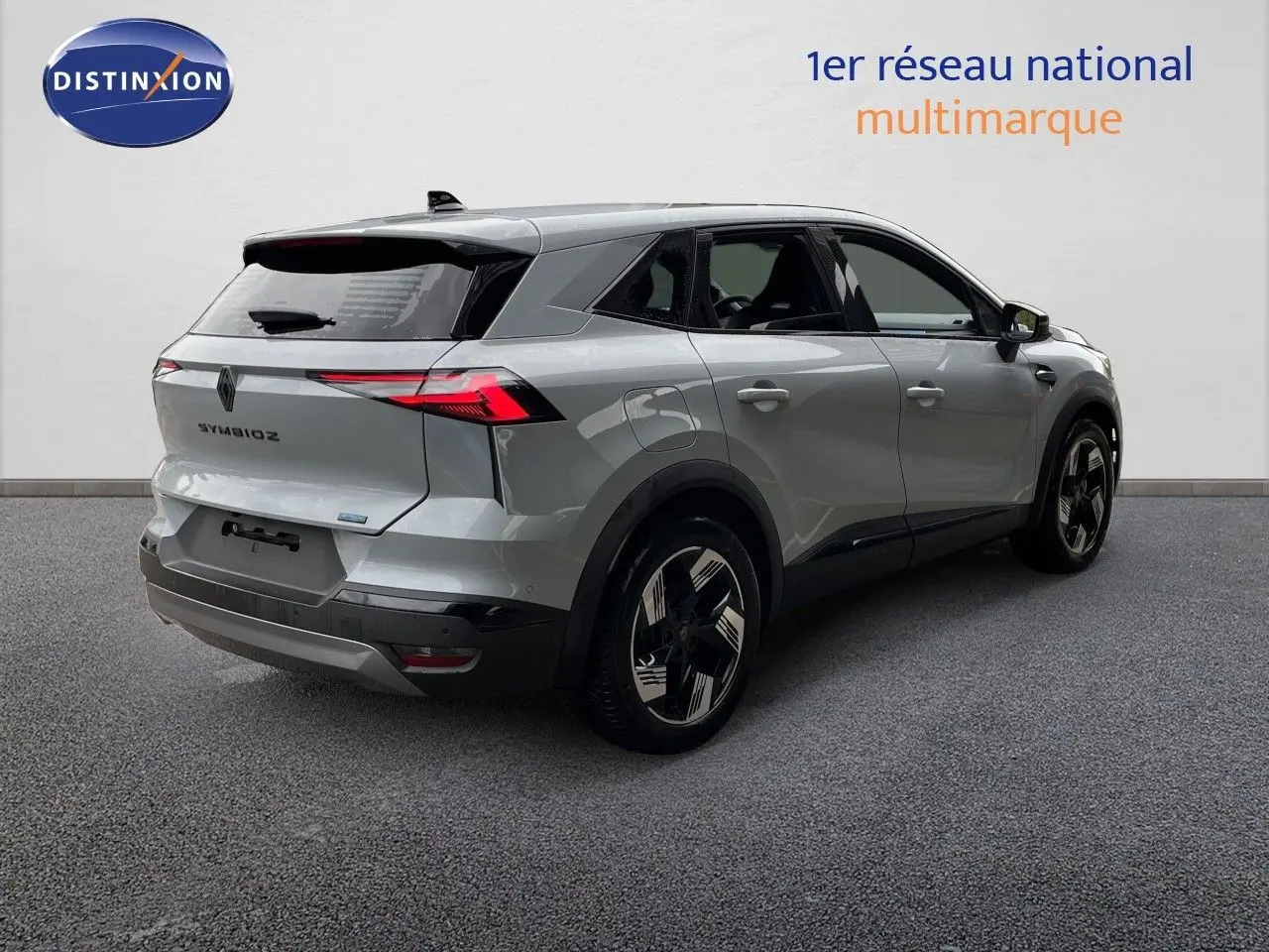 Vue 3/4 arrière droite d’un Renault Symbioz gris Rafale métal avec feux arrière LED et jantes bicolores.