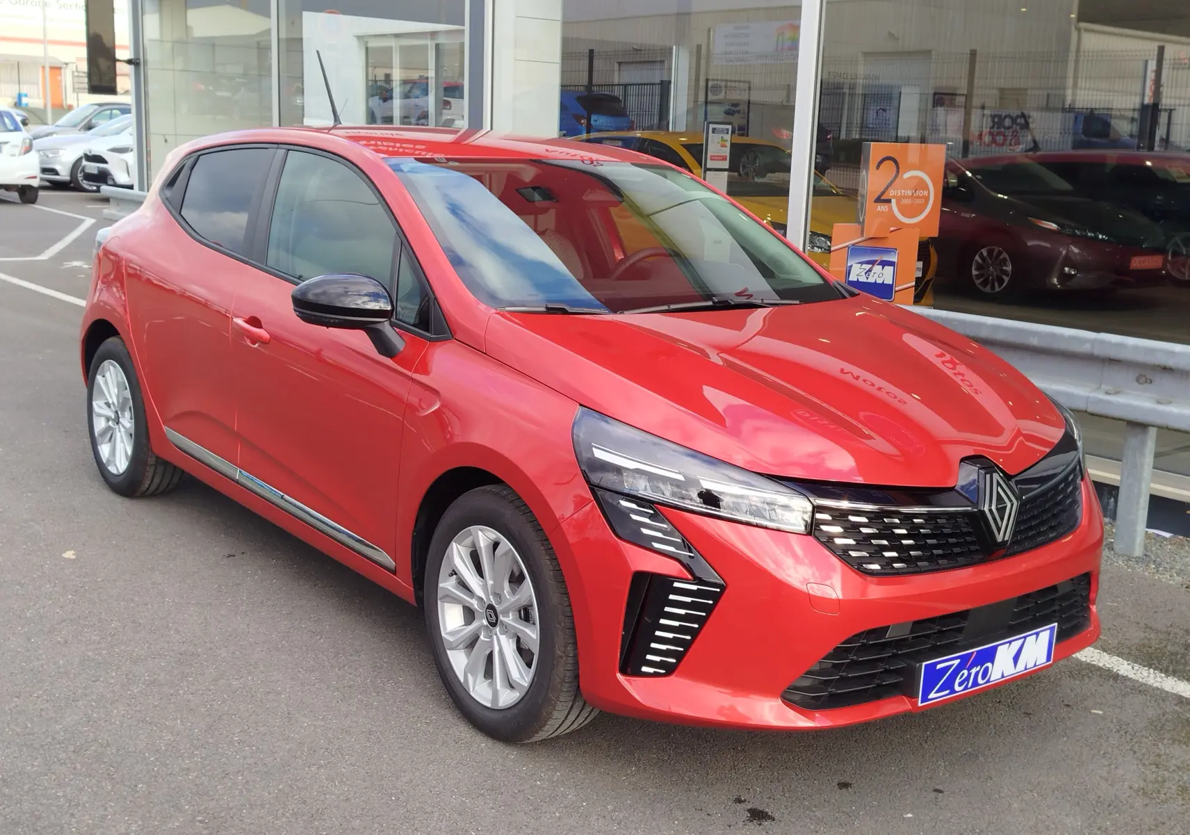 Renault Clio TCe 90ch X-Tronic Evolution rouge flamme vue 3/4 avant avec calandre noire et phares LED distinctifs.