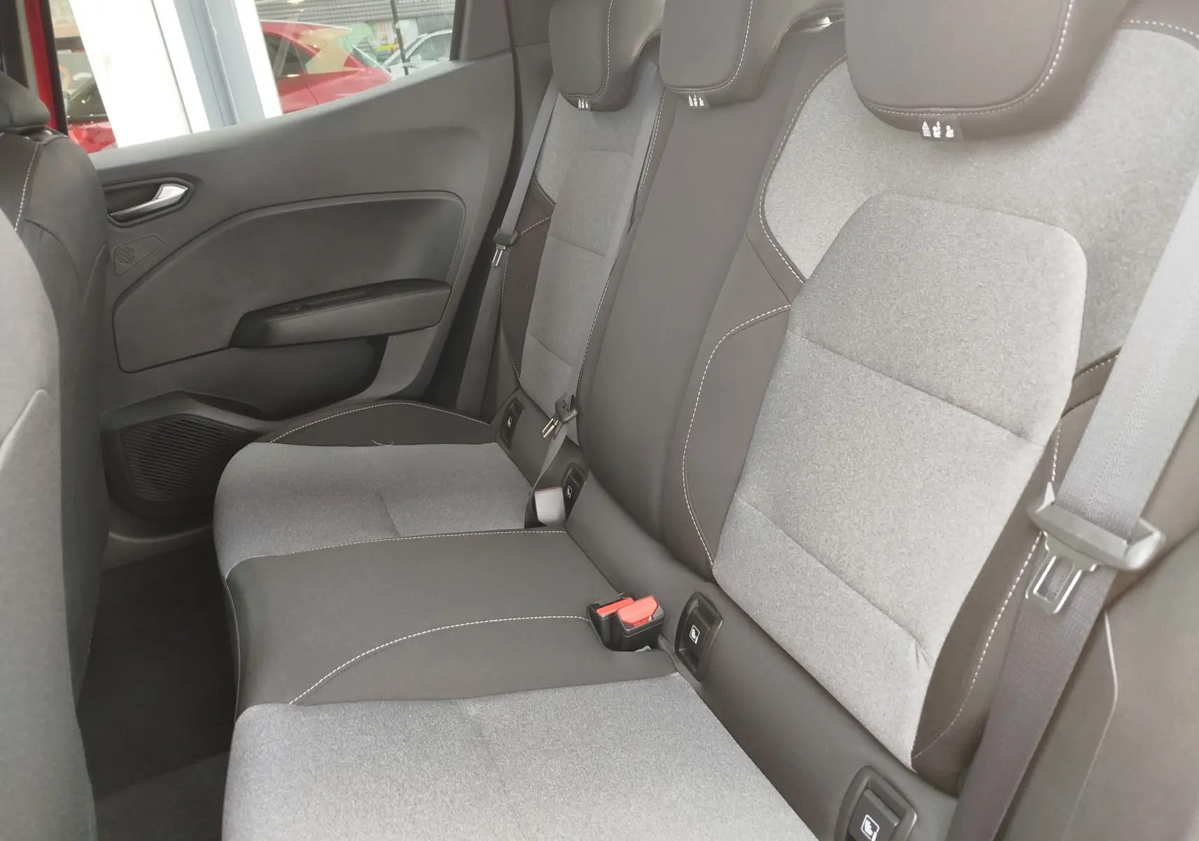 Vue latérale droite de la banquette arrière gris clair et noir avec ceintures et appuie-têtes de la Renault Clio 2025.