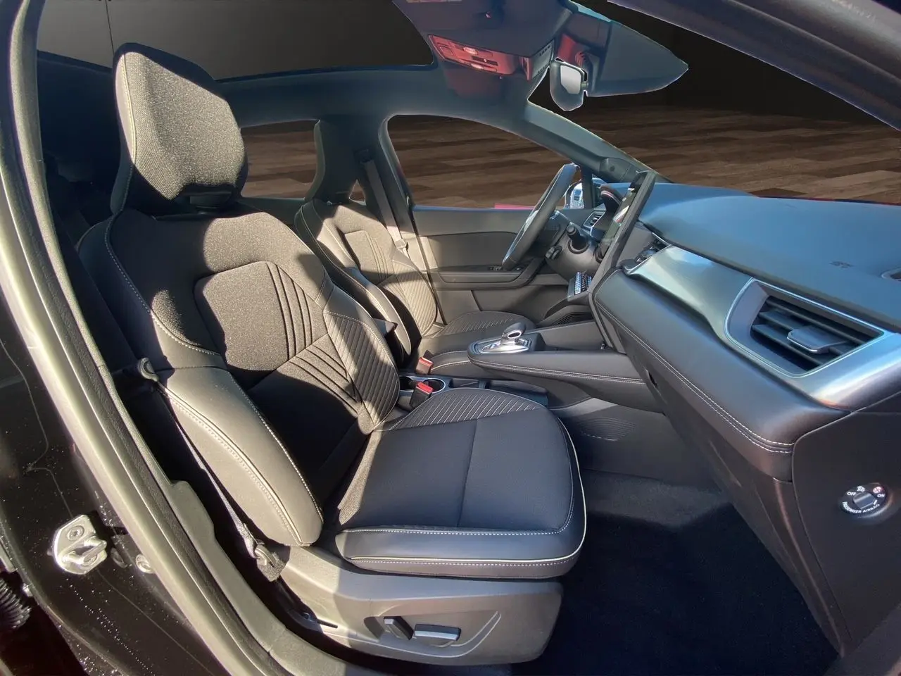 Intérieur noir de la Renault Symbioz 2025, vue côté gauche sur les sièges avant et le tableau de bord moderne.