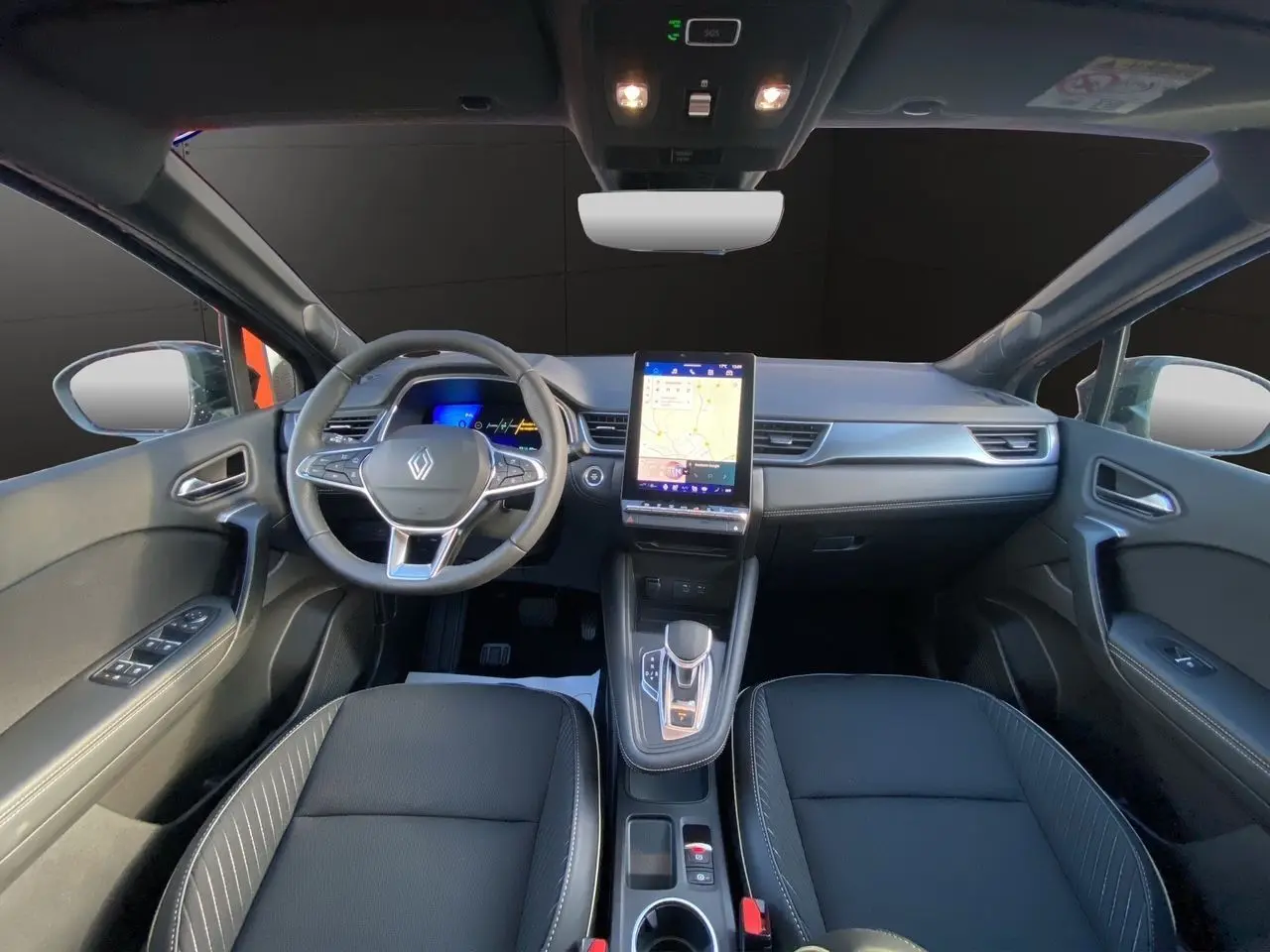 Intérieur noir du Renault Symbioz 2025, vue frontale sur le volant, tableau de bord numérique et écran tactile central.