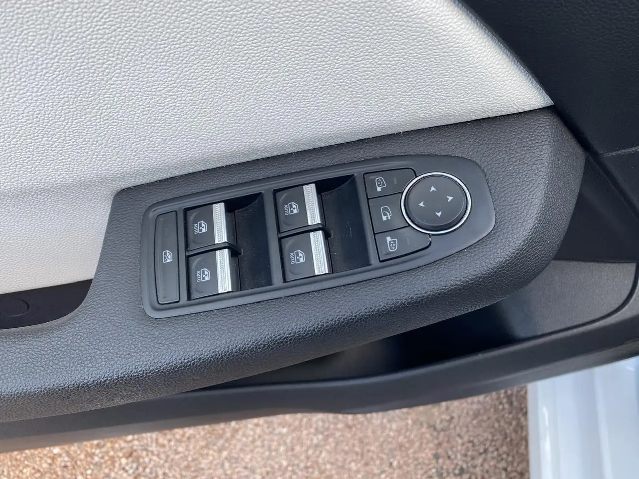 Commande des vitres électriques et réglage des rétroviseurs sur la porte côté gauche d'une Renault Clio blanche 2021.