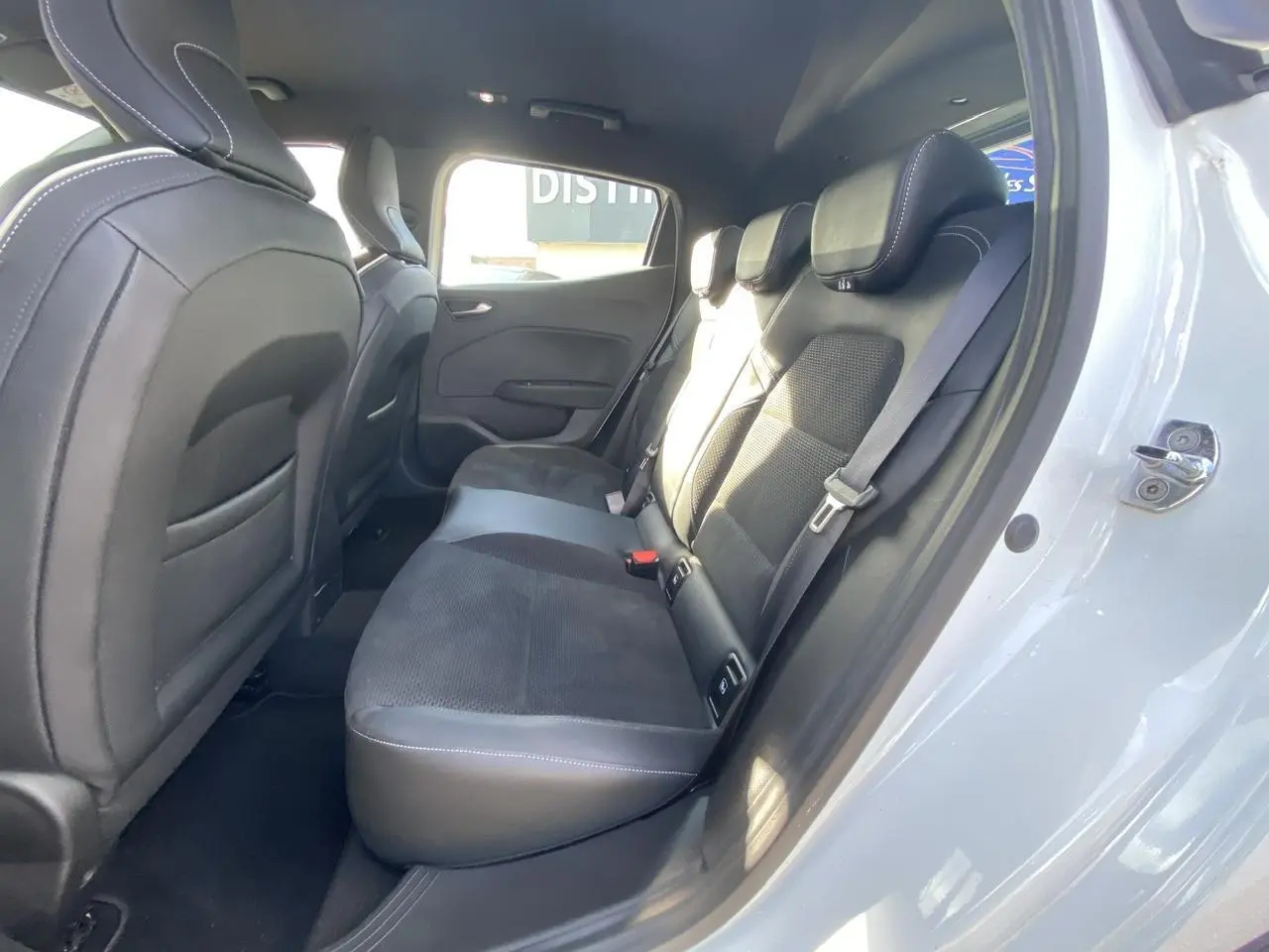 Vue intérieure côté droit sur la banquette arrière en velours et cuir noir d'une Renault Clio blanche 2021.