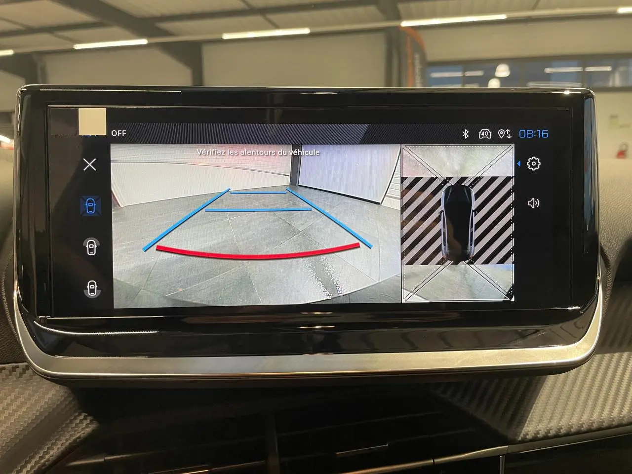 Écran tactile intérieur affichant la caméra de recul et la vue 360° du Peugeot 208 hybride gris Selenium.