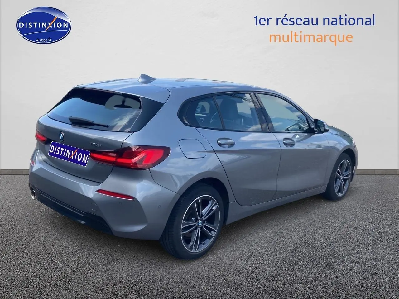 BMW Série 1 gris foncé vue 3/4 arrière côté droit avec jantes alliage et feux arrière LED distinctifs