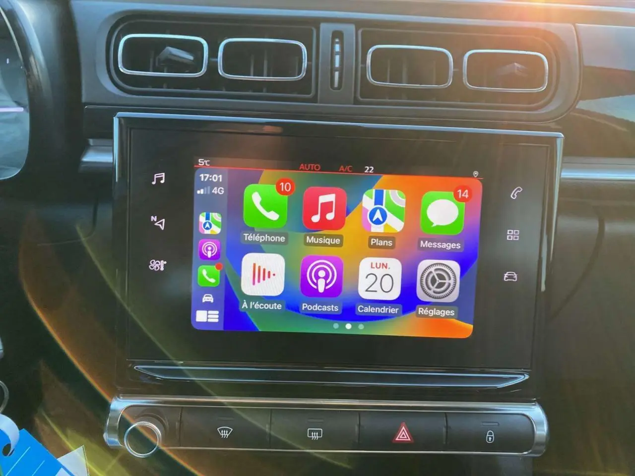 Écran tactile central de la Citroën C3 Shine 2023 affichant Apple CarPlay, entouré de commandes de climatisation et aérateurs rectangulaires.